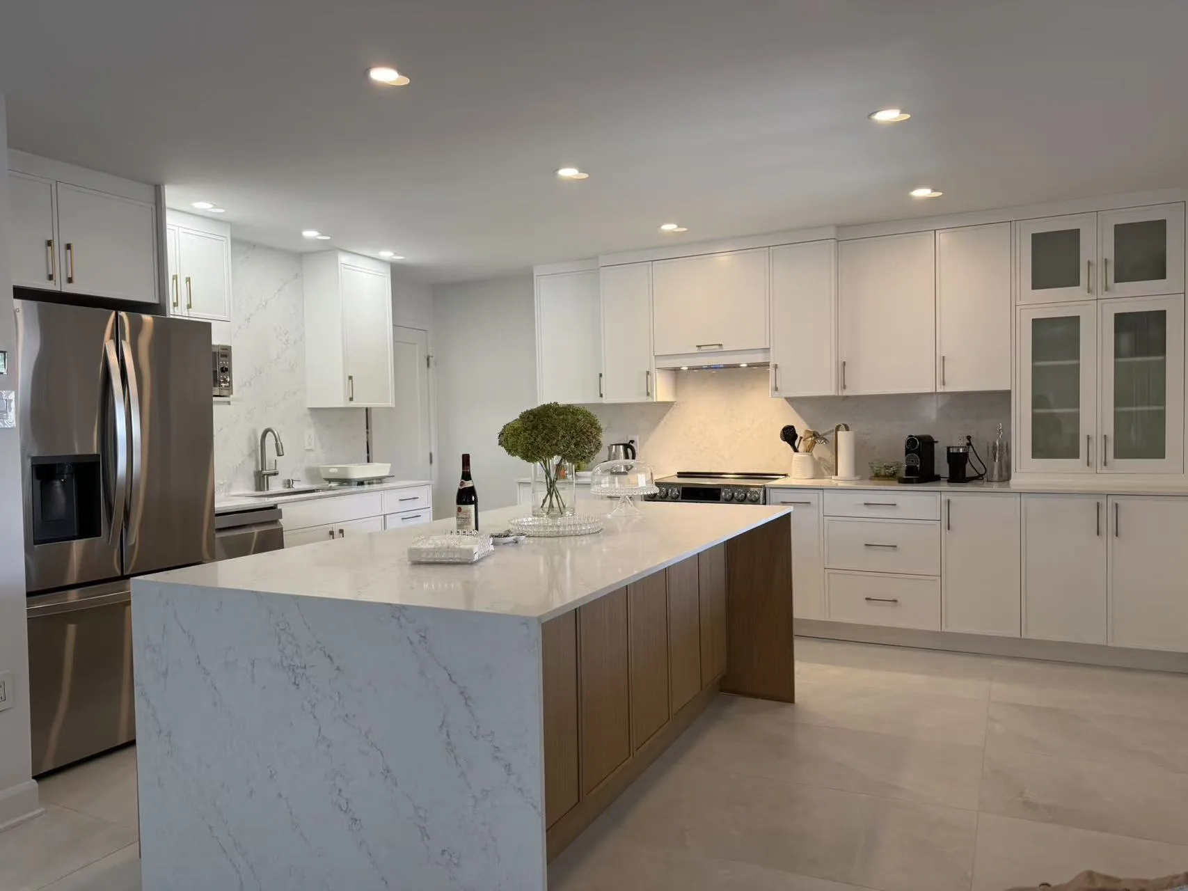 Cuisine sur mesure à Laval avec îlot en bois clair et comptoir de quartz marbré