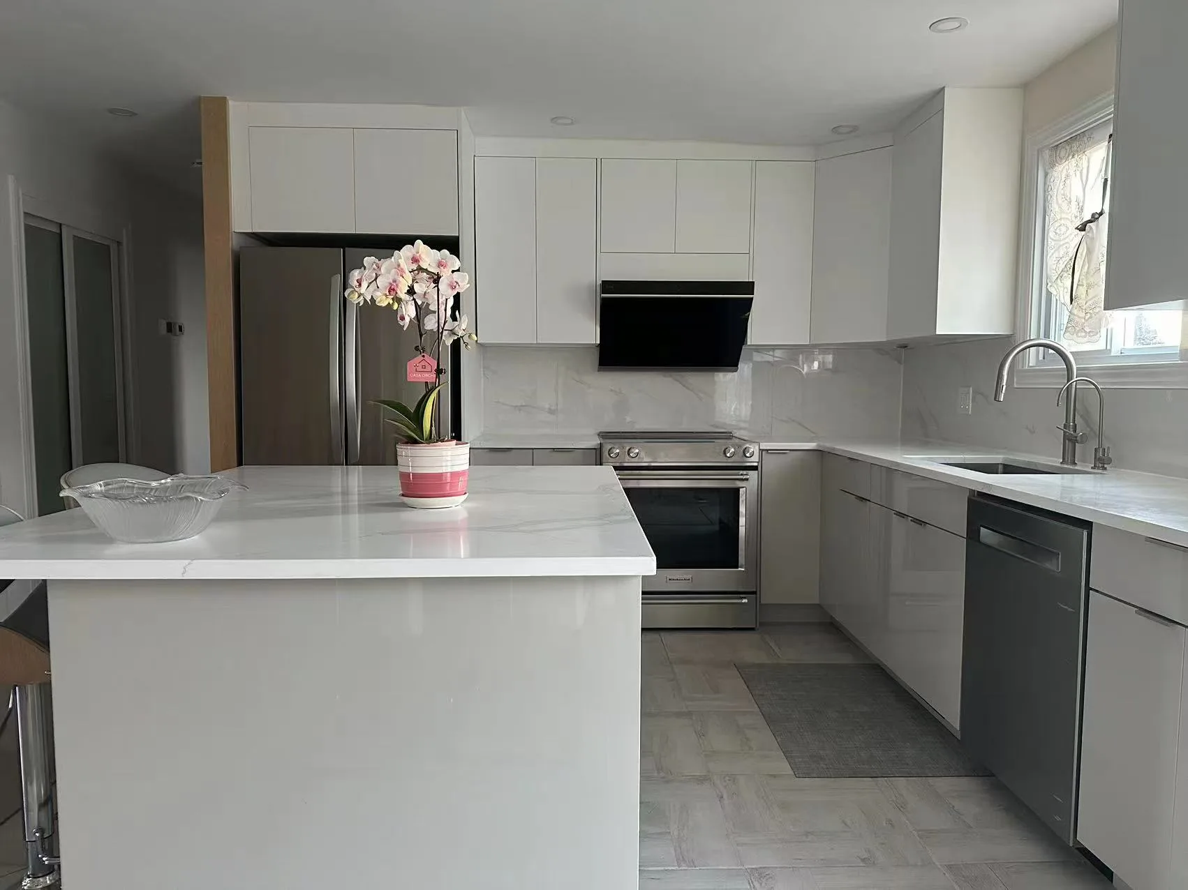 Armoires de cuisine blanches sans poignées et îlot de quartz à Terrebonne