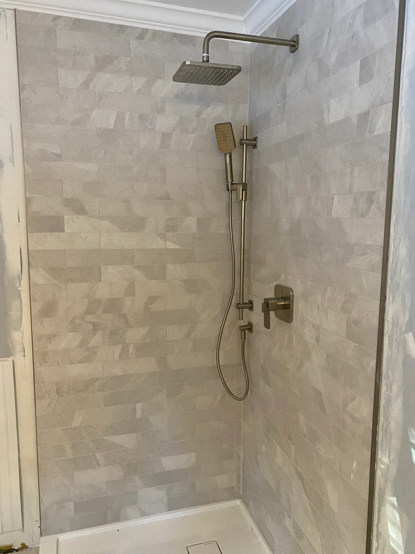 Douche habillée de pierre claire dans une salle de bain rénovée